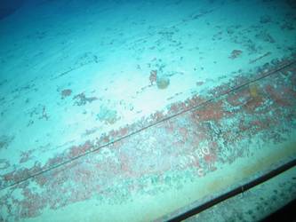 Large section of hull in debris field with "08KO" painted on plating
